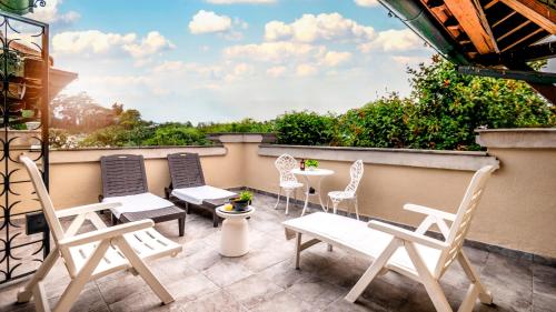 a patio with chairs and tables on a balcony at Villibera - Design villa with SPA, Cinema, Gym and Game Room in Cesano Maderno