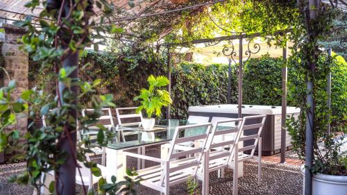 a patio with a table and chairs under a pergola at Villibera - Design villa with SPA, Cinema, Gym and Game Room in Cesano Maderno