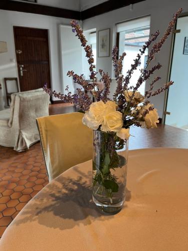 a vase filled with flowers sitting on a table at La Ferme de la Place in Bouvines
