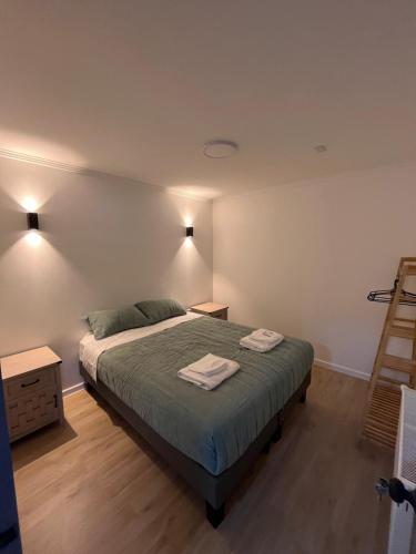 a bedroom with a bed with two towels on it at Patagonia Stay in Puerto Natales