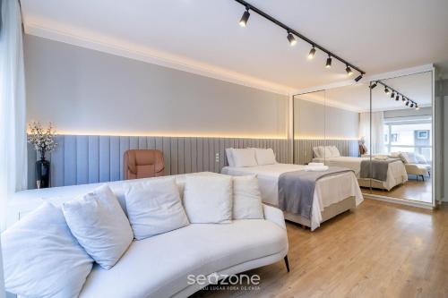 a living room with a couch and two beds at Studio completo a poucos passos da Praia - KPL0806 in São José