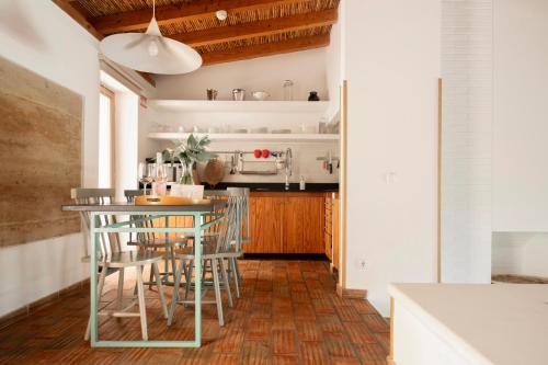 a kitchen with a table and chairs in a room at Monte Da Vilarinha in Carrapateira