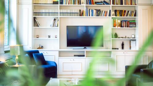 a living room with a tv and a blue couch at Villibera - Design villa with SPA, Cinema, Gym and Game Room in Cesano Maderno