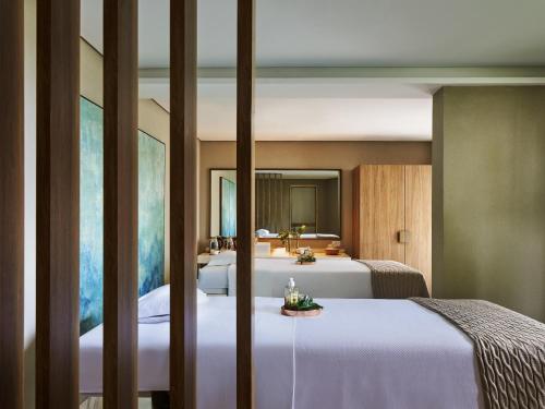a bedroom with two beds and a mirror at Fairmont Rio de Janeiro Copacabana in Rio de Janeiro