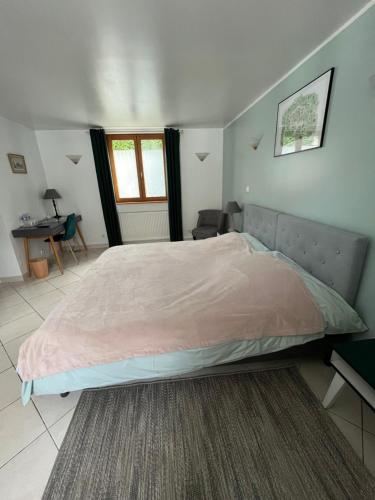 a large bed in a bedroom with a desk at La Ferme de la Place in Bouvines