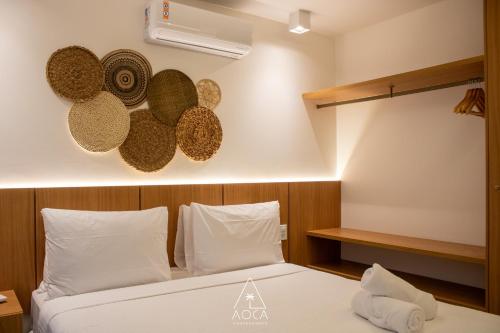 a bedroom with a bed with hats on the wall at Villa Naluri - Seu Refúgio a 50 metros da praia em Japaratinga in Japaratinga