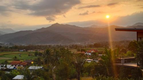 a sunset over a town with mountains in the background at นะลาวิว รีสอร์ท ปัว Nala View Resort Pua in Pua