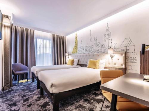 a hotel room with two beds and a table at ibis Styles Lublin Stare Miasto in Lublin