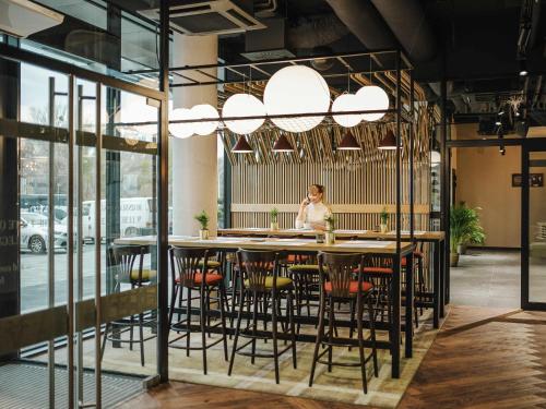 a woman sitting at a table in a restaurant at ibis Styles Lublin Stare Miasto in Lublin