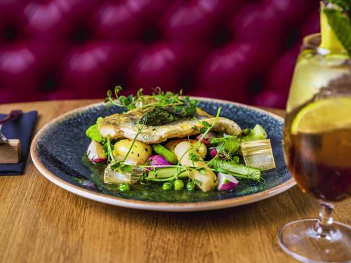 a plate of food with a salad and a glass of wine at ibis Styles Lublin Stare Miasto in Lublin