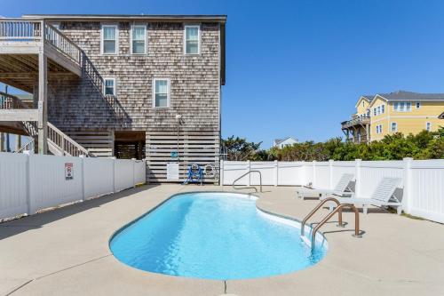 a patio with a swimming pool in front of a building at 8076 - Siren's Serenade in Rodanthe