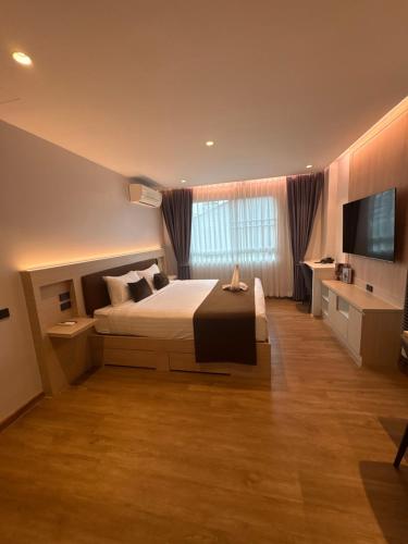 a bedroom with a bed and a flat screen tv at Spacious Bedroom- 2 mins from Train Station in Bangkok