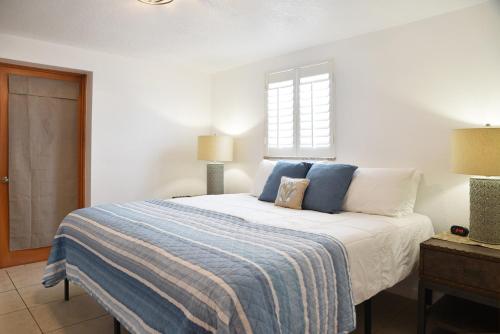 a bedroom with a bed with a blue and white blanket at Enjoy Sunset with Dolphin and Manatee in Hudson