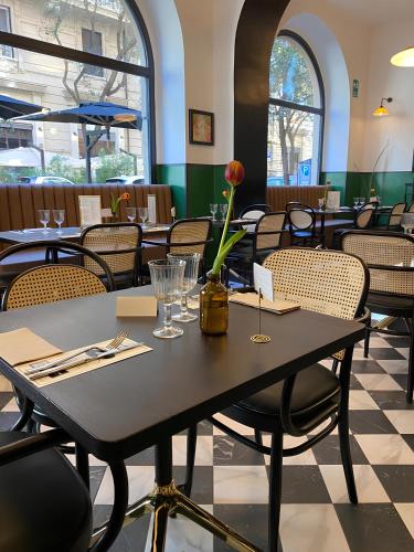 Una mesa con un jarrón de flores en un restaurante. en Carrara 24, en Roma