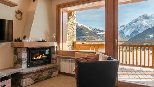 a living room with a fireplace and a mountain view at Villa Nice View in Ponte di Legno