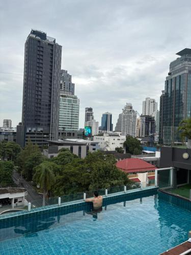 a swimming pool with a city skyline in the background at Spacious Bedroom- 2 mins from Train Station in Bangkok