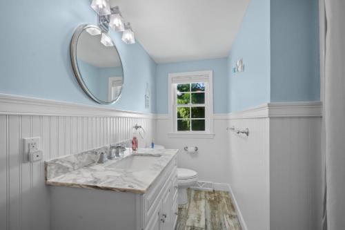 a white bathroom with a sink and a mirror at 111 Eileen Street Yarmouth Port - Starfish Escape in Yarmouth