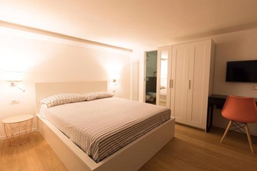 a white bedroom with a bed and a desk at Casa Fabrizio Ai Gradoni Di Chiaia in Naples