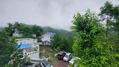 a view of a house with cars parked in a yard at DM Farms Morni Hills Panchkula in Morni