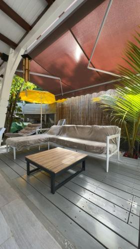 a patio with two beds and a coffee table at Hibiscus Paradise in Vieux-Habitants