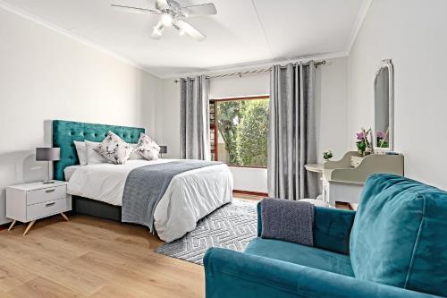a bedroom with a bed and a blue couch at Shai in Johannesburg