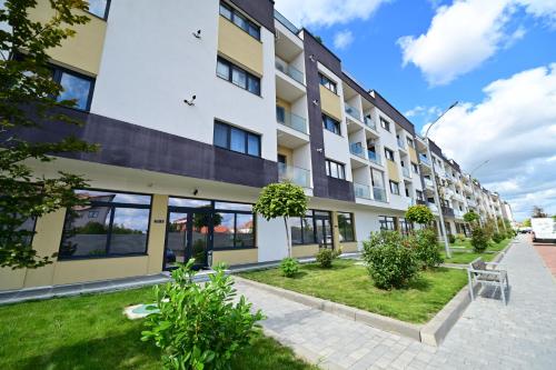 Un edificio de apartamentos con césped delante. en FLH - Garden Residence, en Sibiu