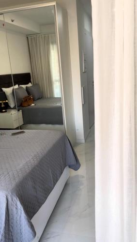 a bedroom with a bed and a large mirror at Studio Lumiere in Sao Paulo