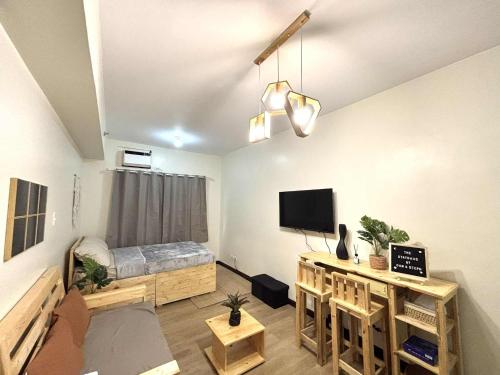 a living room with a bed and a television at The Stayhaus by Dan & Steph in Manila