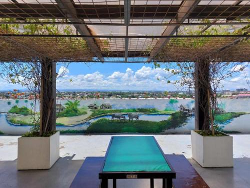 een kamer met een grote muurschildering van een rivier en een tafel bij The Stayhaus by Dan & Steph in Manilla