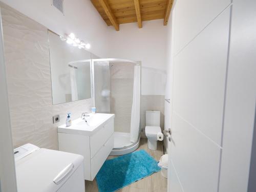 a white bathroom with a sink and a toilet at Los Lagos in El Roque