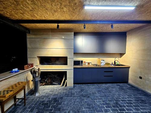 a kitchen with a fireplace and a counter and a table at Arev Rest House in Katʼnaghbyur
