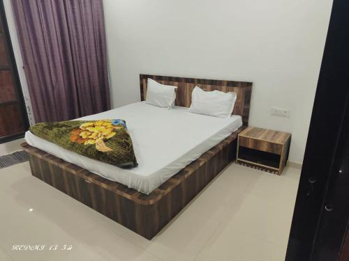 une chambre avec un lit avec des draps blancs et des fleurs dessus dans l'établissement Hotel Nitharwal Palace, à Khātu