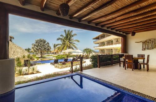 an outdoor swimming pool with a view of a resort at El Secreto Residencial in Zihuatanejo