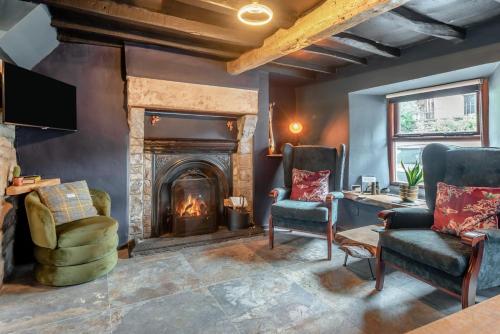 a living room with a fireplace and two chairs at 2 Bed in Ravenstonedale oc-t33208 in Ravenstonedale