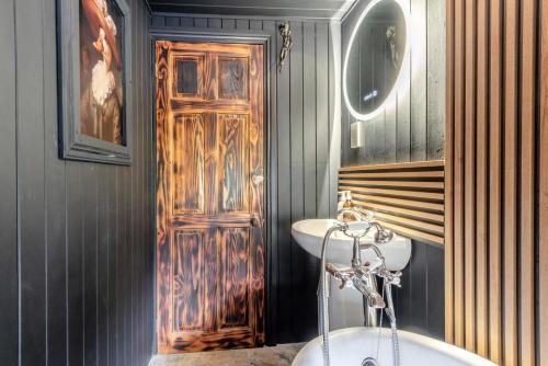 a bathroom with a wooden door and a sink at 2 Bed in Ravenstonedale oc-t33208 in Ravenstonedale