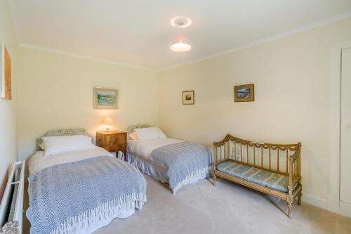 a bedroom with two beds and a bench in it at 3 Bed in Comrie oc-e33307 in Dunira