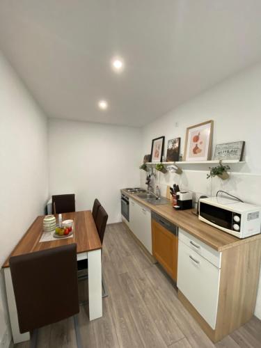 a kitchen with a table and a microwave at Ferienwohnung Nähe Augenklinik in Sulzbach
