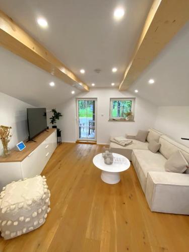 a living room with a white couch and a table at Cozy Alpenloft Chiemsee by Dollop Living in Bernau am Chiemsee
