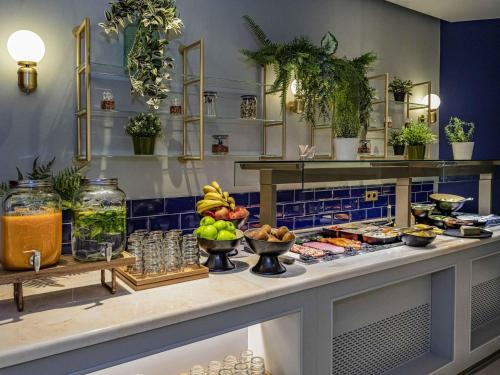 a buffet with a lot of food on a counter at Maek Hotel Antwerp Central - Handwritten Collection in Antwerp