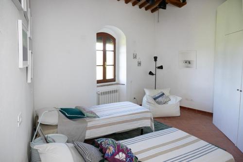 una habitación con tres camas y un sofá en La Loggetta, authentic Tuscany, en Colle Val D'Elsa
