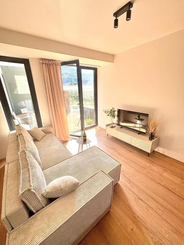 a living room with a couch and a large window at Moderný apartmán so súkromnou terasou v centre mesta in Banská Bystrica
