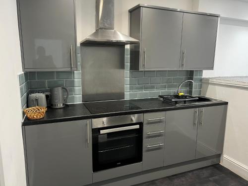 a kitchen with white cabinets and a stove top oven at Beach & city Homestay in Waterloo
