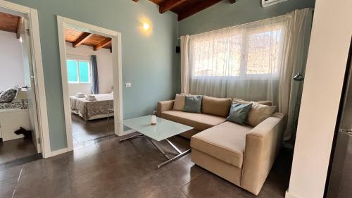 ein Wohnzimmer mit Sofa und Tisch in der Unterkunft Spacious Country House Near Fataga in Artedara