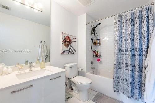 a bathroom with a toilet and a sink and a tub at Luxury Loft 270 views Rooftop Pool Parking in Miami