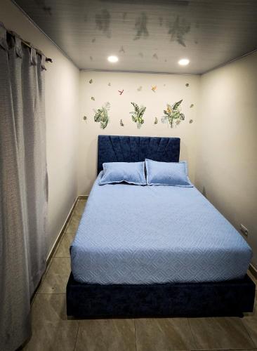 a bedroom with a bed with a blue head board at Fly & Stay Bogota APT 2 in Bogotá
