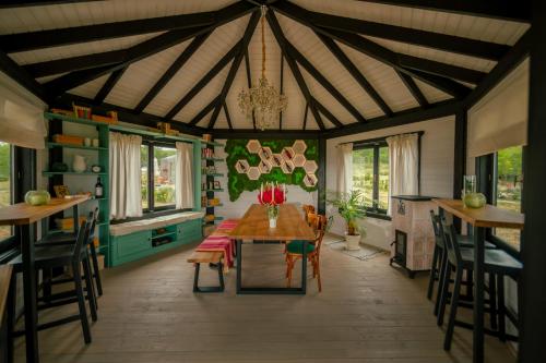 una sala da pranzo con tavolo, sedie e lampadario di 1001 Village a Jugureni
