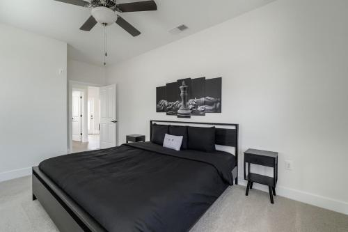 a bedroom with a black bed and a ceiling fan at Stylish Condo 3 Bedroom with Pool Table in Homewood