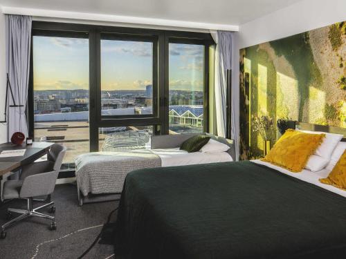 a hotel room with two beds and a large window at Novotel Paris Porte Versailles in Paris