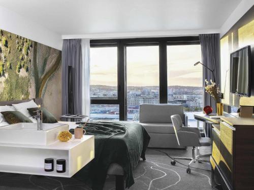 a hotel room with a bed and a desk with a sink at Novotel Paris Porte Versailles in Paris