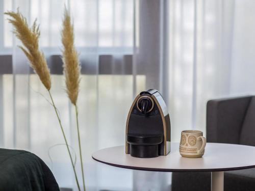 a coffee maker on a table next to a coffee mug at Novotel Paris Porte Versailles in Paris